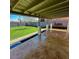 Inviting covered patio with textured concrete, overlooking a spacious backyard with mature trees and lush green lawn at 1017 S Lola Ln, Tempe, AZ 85281