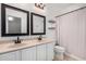 Bright bathroom featuring double sinks, an updated vanity, and a separate shower and toilet area at 10932 E Bella Via --, Mesa, AZ 85212