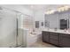 Bright bathroom with a glass shower, soaking tub, double vanity, and decorative glass block window at 10932 E Bella Via --, Mesa, AZ 85212
