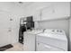 Bright laundry room featuring a washer, dryer, storage cabinets, and tiled floors at 10932 E Bella Via --, Mesa, AZ 85212