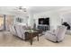 Bright living room with tiled floors, comfortable gray seating, and a modern entertainment center at 10932 E Bella Via --, Mesa, AZ 85212