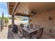 Covered outdoor dining area with ceiling fan, grill, and a view of the sparkling pool at 10932 E Bella Via --, Mesa, AZ 85212