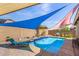 Backyard pool with sun shades, waterfall feature, and desert landscaping at 10932 E Bella Via --, Mesa, AZ 85212