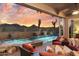 Stunning backyard featuring a pool, spa, waterfalls, covered patio, and comfortable seating with desert views at 11053 E Hedgehog Pl, Scottsdale, AZ 85262