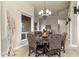 Dining area with a round wood table, chandelier lighting, and views into the living room at 11053 E Hedgehog Pl, Scottsdale, AZ 85262