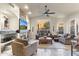 Living area featuring a stone fireplace, ceiling fan, tile floors, and a view of the backyard at 11053 E Hedgehog Pl, Scottsdale, AZ 85262