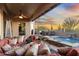Inviting outdoor living area with a private pool, seating, and desert views at sunset at 11053 E Hedgehog Pl, Scottsdale, AZ 85262