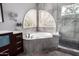 Soaking tub with a view next to a glass shower with tiled walls and river rock floor at 1210 E Azure Sea Ln, Gilbert, AZ 85234