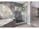 Luxurious bathroom with a glass-enclosed shower, tub, and elegant tile work at 1210 E Azure Sea Ln, Gilbert, AZ 85234