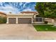 Two-car garage with a neutral color scheme, complemented by lush landscaping and a well-maintained lawn at 1210 E Azure Sea Ln, Gilbert, AZ 85234