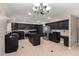 A spacious kitchen features black cabinetry, stainless steel appliances, an island, and tile floors for easy maintenance at 1210 E Azure Sea Ln, Gilbert, AZ 85234
