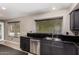 Kitchen sink area featuring black cabinets, granite countertops, stainless steel appliances, and a view of the backyard at 1210 E Azure Sea Ln, Gilbert, AZ 85234