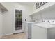 Bright laundry room with white washer and dryer, and door to the outside at 1210 E Azure Sea Ln, Gilbert, AZ 85234