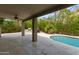 Covered patio with built-in grill overlooks the refreshing pool and lush landscaping at 1210 E Azure Sea Ln, Gilbert, AZ 85234