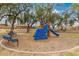 Colorful playground with climbing wall, slide and benches surrounded by trees and wood chips at 1210 E Azure Sea Ln, Gilbert, AZ 85234