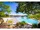 Beautiful lagoon style pool surrounded by lush greenery and beach area with lounge chairs, perfect for relaxation at 1210 E Azure Sea Ln, Gilbert, AZ 85234