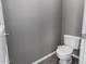 A minimalist powder room showcasing a toilet and neutral-colored walls at 1210 E Azure Sea Ln, Gilbert, AZ 85234