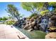 Scenic water feature with multiple waterfalls cascading over rocks, creating a tranquil atmosphere at 1210 E Azure Sea Ln, Gilbert, AZ 85234