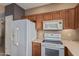 Modern kitchen featuring white appliances, microwave, and plenty of cabinet space at 14000 N 94Th St # 3147, Scottsdale, AZ 85260