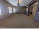 Living room with carpet, chandelier, two windows with blinds, and arched doorway at 14000 N 94Th St # 3147, Scottsdale, AZ 85260