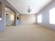 Open living room with carpet, chandelier, and large windows at 14000 N 94Th St # 3147, Scottsdale, AZ 85260