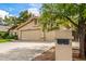 Front view of a house with three-car garage, mailbox and green trees at 15027 N 61St Pl, Scottsdale, AZ 85254