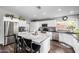 Bright kitchen with stainless steel appliances, white cabinets, a large island, and dark countertops at 15027 N 61St Pl, Scottsdale, AZ 85254