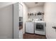 Efficient laundry room with ample shelving and modern side-by-side washer and dryer units at 15027 N 61St Pl, Scottsdale, AZ 85254