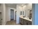 Bathroom featuring double vanities with gray cabinets and a glass-enclosed shower at 15784 W Beryl Ave, Waddell, AZ 85355