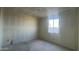 Bright bedroom with a large window providing natural light, complemented by neutral-toned walls at 15784 W Beryl Ave, Waddell, AZ 85355