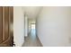 Bright hallway with tile flooring, leading towards a sunlit room with sliding glass doors at 15784 W Beryl Ave, Waddell, AZ 85355