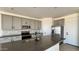 Modern kitchen with gray cabinets, granite countertops, stainless steel appliances, and an island with a sink at 15784 W Beryl Ave, Waddell, AZ 85355
