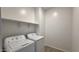Efficient laundry room with washer, dryer, shelving and tile flooring at 15784 W Beryl Ave, Waddell, AZ 85355
