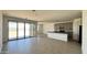 Open-concept living room flows into the kitchen with a kitchen island and backyard access through glass doors at 15784 W Beryl Ave, Waddell, AZ 85355