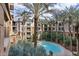 A community pool and surrounding apartment buildings with many palm trees at 1701 E Colter St # 311, Phoenix, AZ 85016