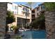 A clear swimming pool with lounge chairs, palm trees, and a wall of windows, offering a relaxing and luxurious setting at 1701 E Colter St # 311, Phoenix, AZ 85016