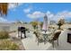 Landscaped backyard featuring a built-in grill, outdoor furniture, a soothing rock waterfall and blue sky at 18360 N 169Th Ave, Surprise, AZ 85374