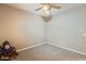 This empty carpeted bedroom has a ceiling fan and electrical outlets at 18360 N 169Th Ave, Surprise, AZ 85374