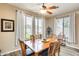 Cozy dining area with wood table and chairs, large windows, and modern ceiling fan at 18360 N 169Th Ave, Surprise, AZ 85374