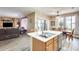 Open-concept kitchen with an island, wood cabinets, and a view of the living area and dining space at 18360 N 169Th Ave, Surprise, AZ 85374