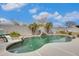 Backyard pool with waterfall feature, surrounded by mature landscaping and a patio area for relaxation at 18360 N 169Th Ave, Surprise, AZ 85374