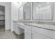 Bright bathroom featuring double sinks, granite counters, white cabinetry and a shower in the background at 18988 W Cortez St, Surprise, AZ 85388