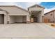 Exterior of home featuring attached three-car garage and paver driveway and walkway at 18988 W Cortez St, Surprise, AZ 85388