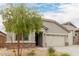 Charming single-story home featuring a three car garage, desert landscaping, and a stone facade at 18988 W Cortez St, Surprise, AZ 85388