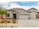 Charming single-story home featuring a three car garage, desert landscaping, and a stone facade at 18988 W Cortez St, Surprise, AZ 85388
