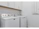 Bright laundry room with modern Maytag washer and dryer units and white cabinets above at 18988 W Cortez St, Surprise, AZ 85388