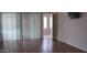 Open living room with wood flooring and sliding glass door out to balcony at 20479 N 105Th Ave, Peoria, AZ 85382
