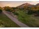 Tranquil walking path surrounded by native desert flora and a majestic mountain backdrop at sunset at 21975 S 193Rd Way, Queen Creek, AZ 85142