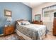 Charming bedroom with blue accents, featuring wood floors, a decorative bedspread, and ample natural light at 2212 W Calle De Las Estrella St, Phoenix, AZ 85085