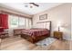 Comfortable bedroom with a wood floor, ceiling fan and ample natural light from a large window at 2212 W Calle De Las Estrella St, Phoenix, AZ 85085